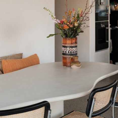 De Limoges betonlook eettafel met organische vormen in een keuken.ALT