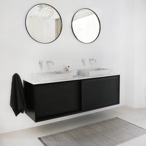 moderne zwarte badkamerkast met schuifdeuren en witmarmeren wastafelplaat en wastafel alt